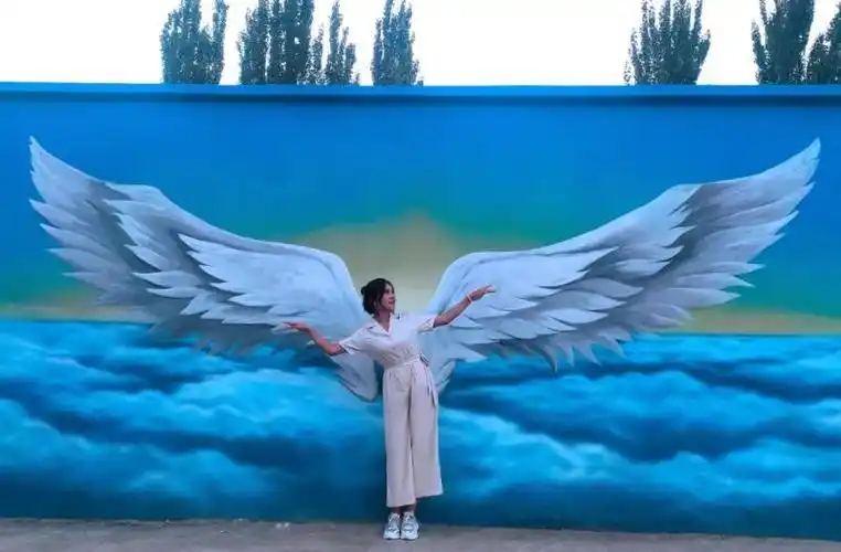 里村口看到天使的翅膀墙绘,第一眼就心动了,情不自禁地过去打卡拍照