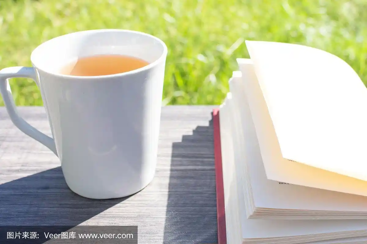 清晨,木桌上放着一杯茶和一本书