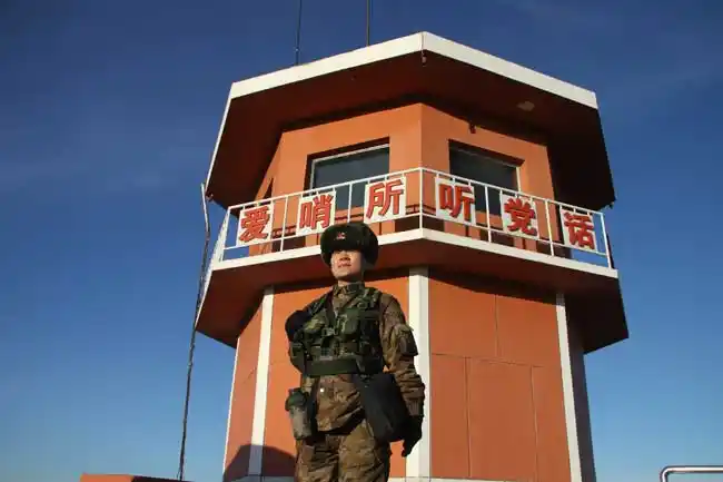 女兵持枪站在岗楼下,腰杆笔挺,充满自豪.