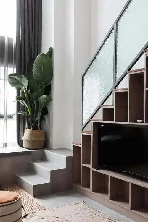 9通往二层的楼梯也不能浪费,楼梯下定做了一墙的电视柜,不仅可以摆放