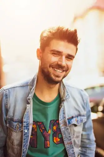 微笑和快乐的酷男人,看着相机,过着愉快的一天,与一个现代人在街上的