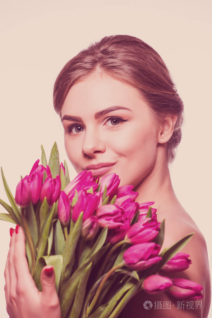漂亮的女人抱着郁金香花束的特写肖像