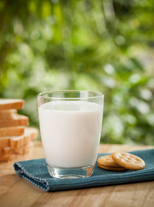 早餐包括新鲜鸡蛋,牛奶杯和面包照片