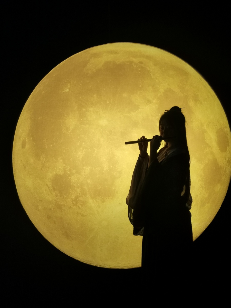 月亮前吹竹笛的汉服女孩