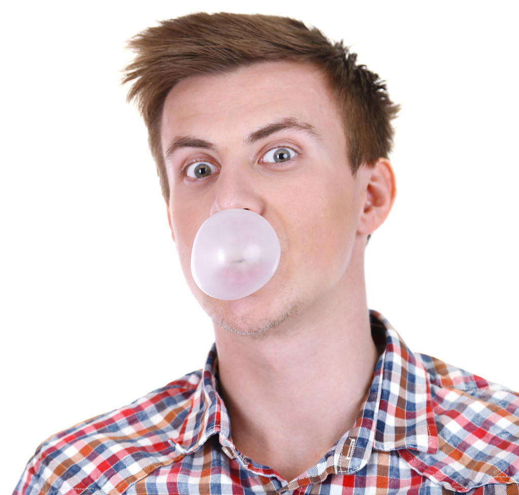 吹泡泡口香糖上白色孤立的年轻人