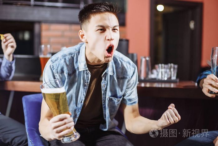 在酒吧里喝啤酒的情绪年轻男子