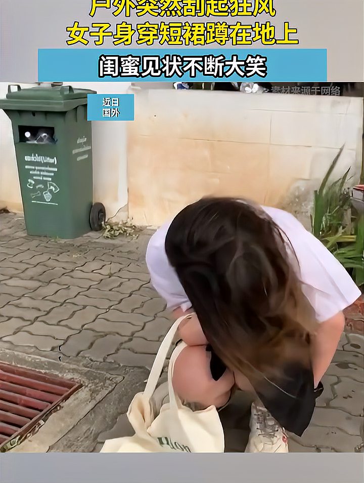 户外突然刮起狂风女子身穿短裙蹲在地上闺蜜见状不断大笑