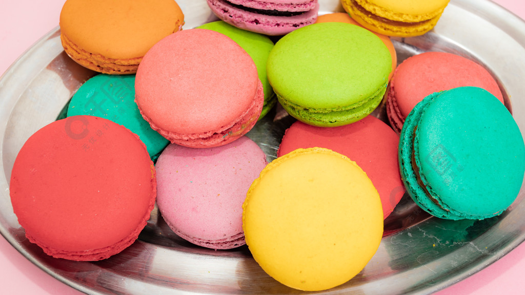 粉红色背景中的甜点蛋糕马卡龙或马卡龙