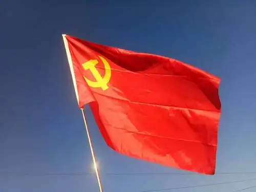 鲜红党旗飘扬在蔚蓝的天空下