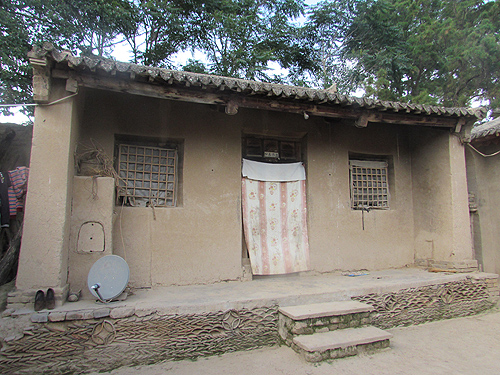 图为小奋家修缮前破旧的泥土房