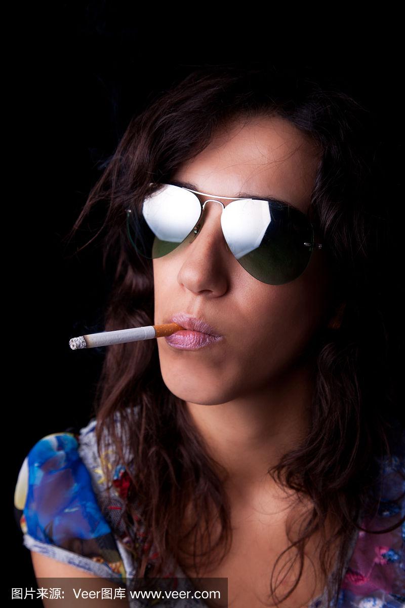 年轻性感的黑发女人,抽烟,戴着墨镜