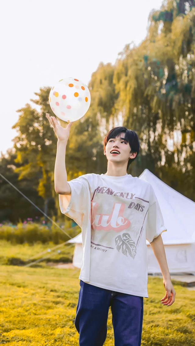 傍晚的晚霞衬托出宋亚轩的皮肤白皙细腻,双手在脸颊比耶更是青春活力