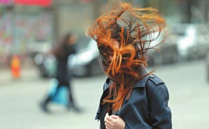 昨天的天气让长春的美女们很没面子,一名出行的女子头发被吹乱 新文化