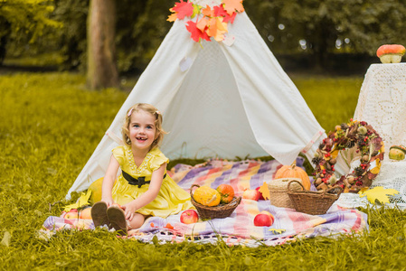 小女孩躺在帐篷里玩耍, 孩子们的房子在公园里的帐篷里, 秋天可爱的