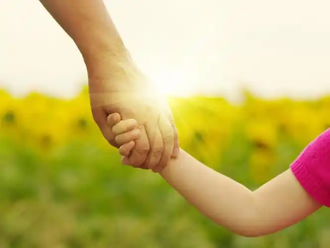 夕阳下妈妈和女儿互相牵手