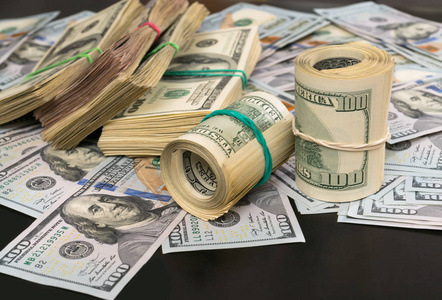 一大堆现金,一大堆100美元的钞票捆绑在一起,以商业成功,财务或腐败的
