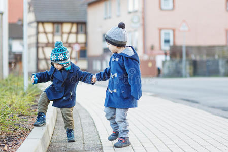 两个兄弟姐妹走在德国村庄的街上.照片