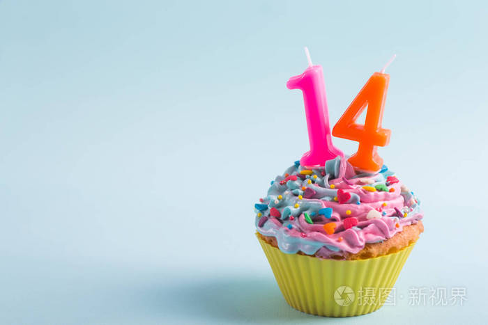 特写节日奶油纸杯蛋糕与洒和蜡烛形式的数字14在紫色背景情人节浪漫