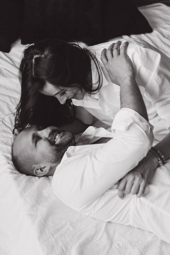 恋爱中的情侣怀孕躺在床上拥抱等待婴儿