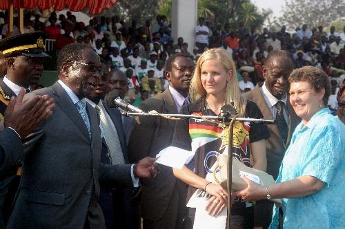 上图为2008年8月29日,津巴布韦总统(左二)为该国白人游泳运动员考文垂