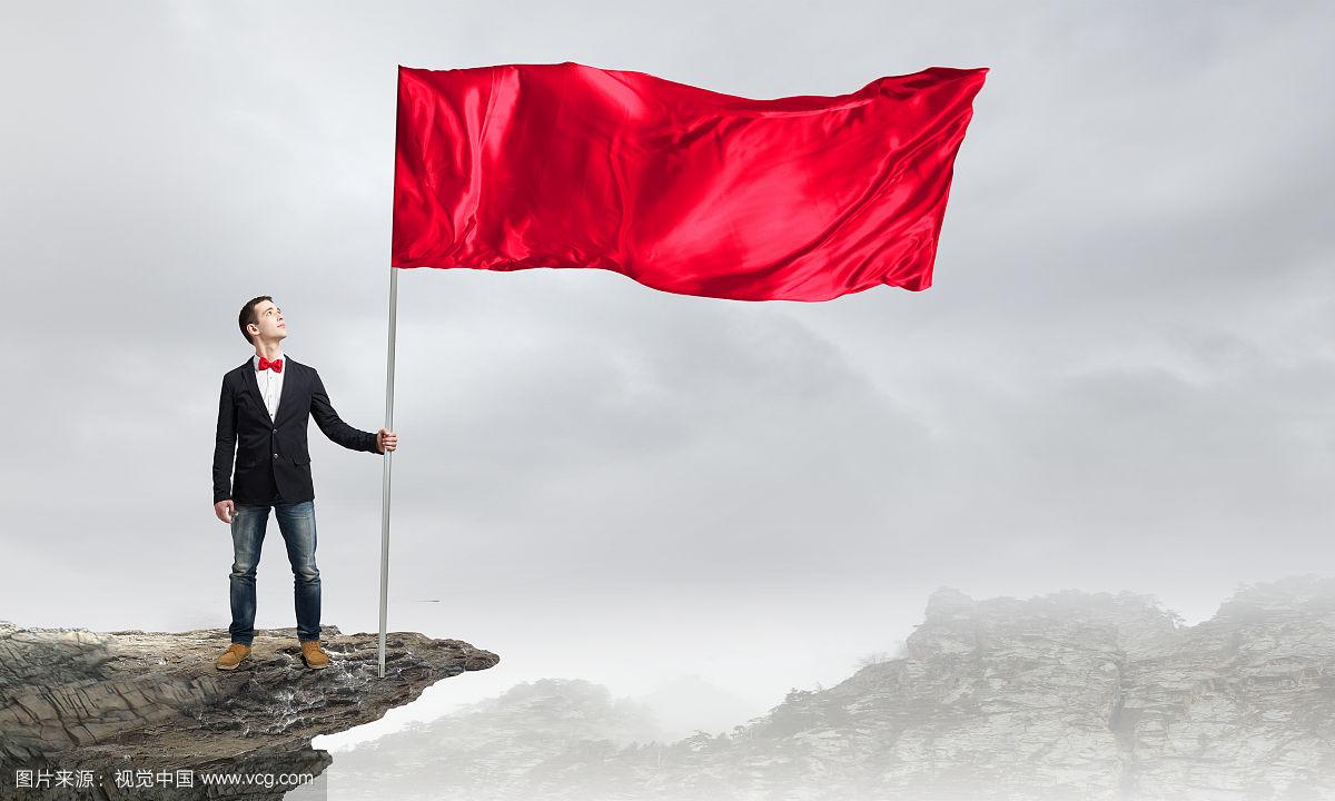 拿着红旗的家伙.打着领结,挥舞着红色旗子的年轻人