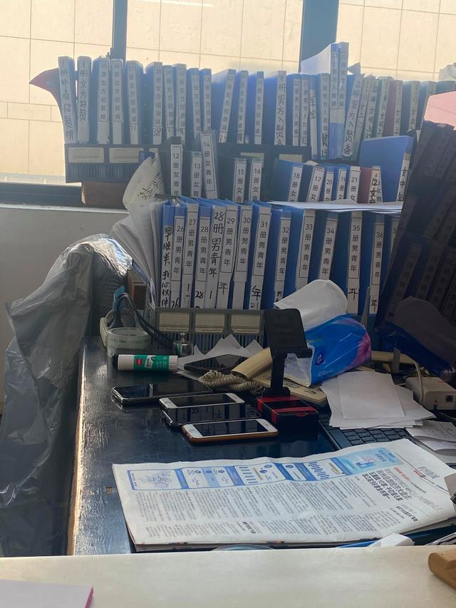 李继延的办公桌上摆着6部手机和许多收录会员资料的文件夹.