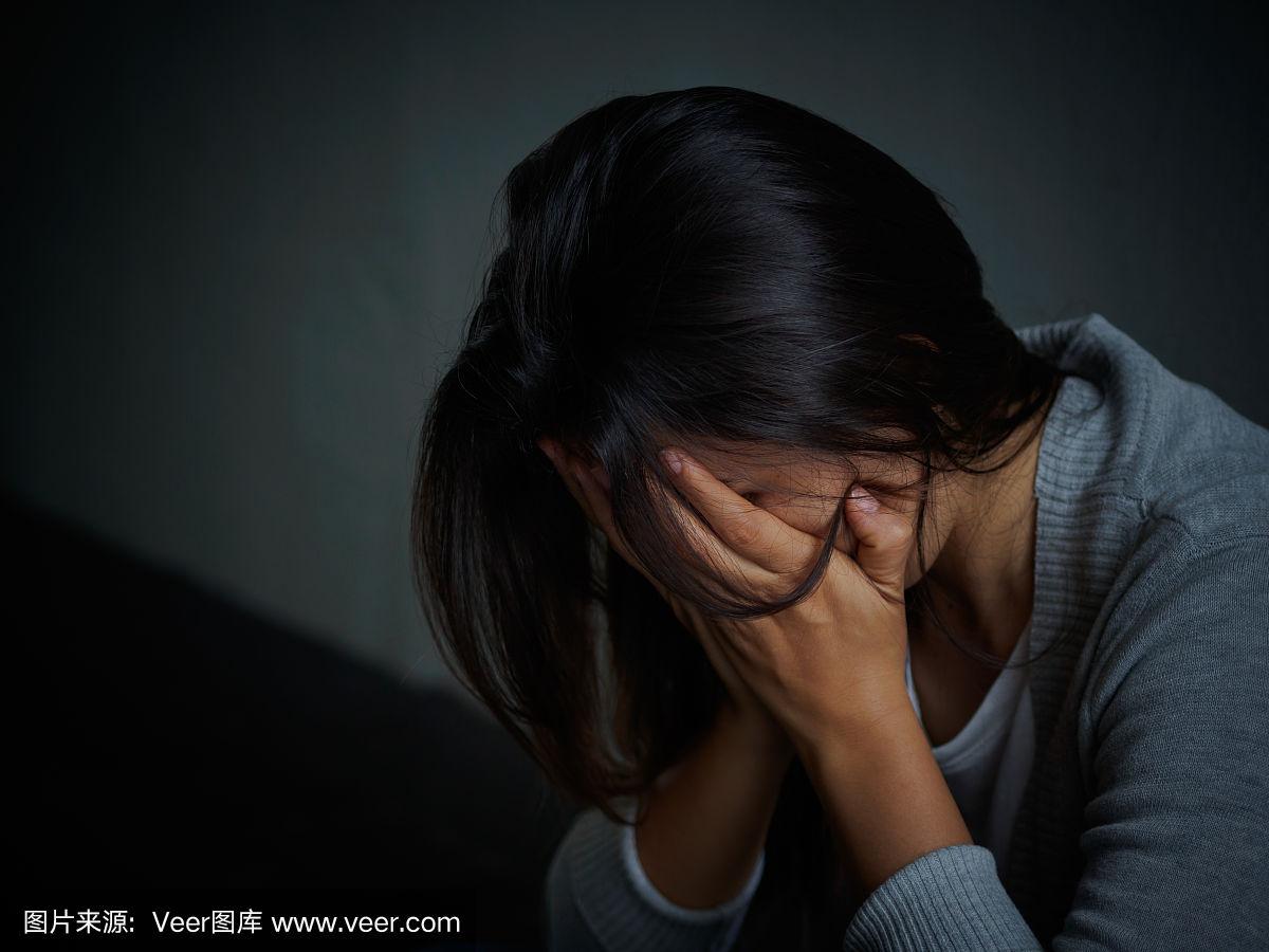 悲伤的女人抱着膝盖哭泣.