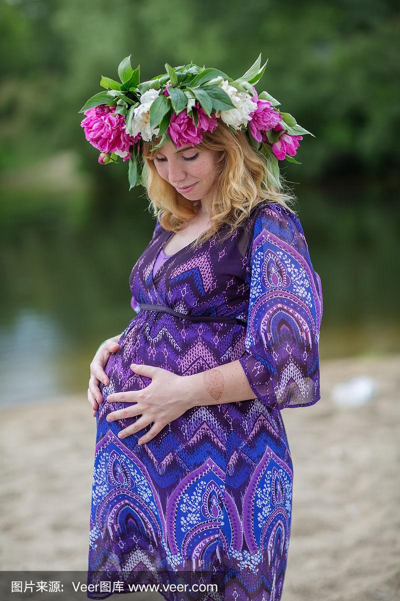 孕妇可爱的女人在阳光明媚的夏日