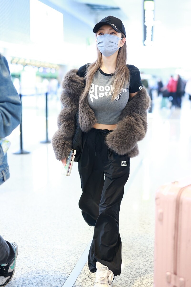 周扬青机场街拍,身穿棕色皮草内搭紧身短t恤,搭配工装阔腿裤,个性时尚