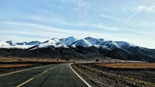 笔直的公路在雪山脚下环绕