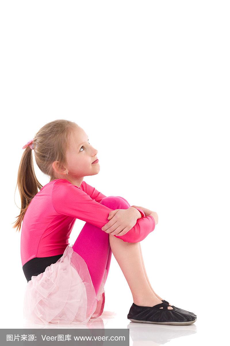 小女孩坐在地板上,侧视.