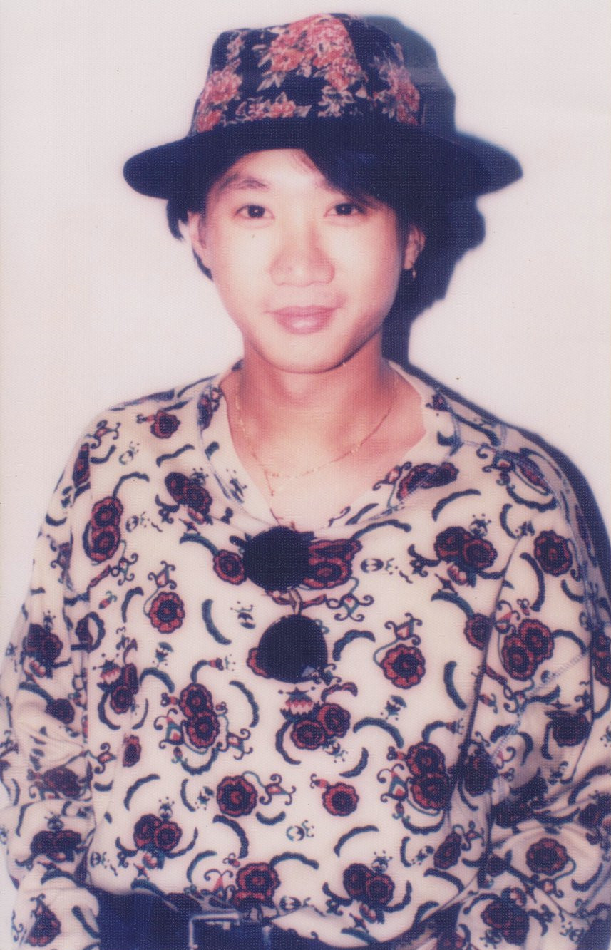 找一张黄家驹的照片,帽子和衣服有花,帽子是黑色,衣服是白色.