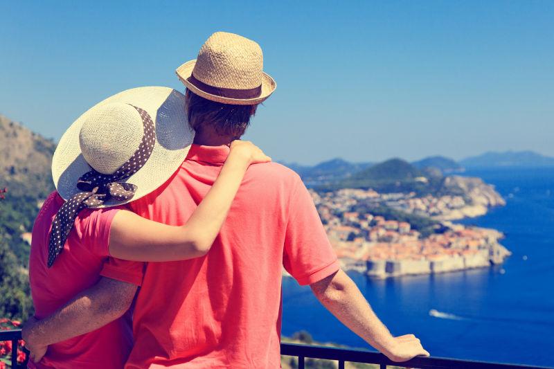 恩爱的夫妻在在海边看着蓝色的大海