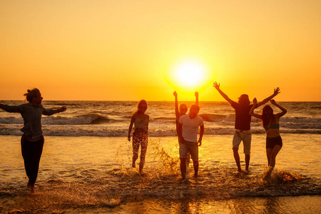 多元文化的多国快乐的人们在阳光下奔跑,无忧无虑,在海上度假照片