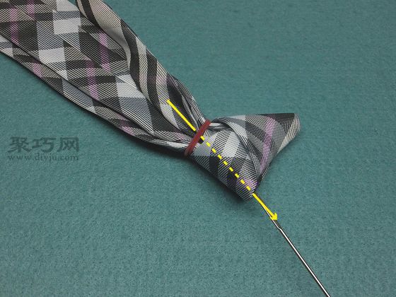 使其穿过领带的结.如果难以通过,请稍微松开橡皮筋.