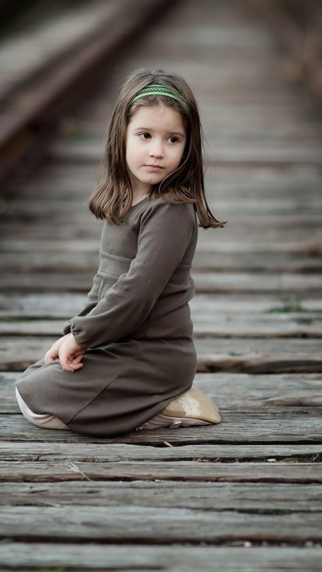 可爱的小女孩坐在铁路上,孩子,回头看