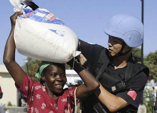 在海地首都太子港,中国赴海地维和警察防暴队队员帮助地震受灾居民