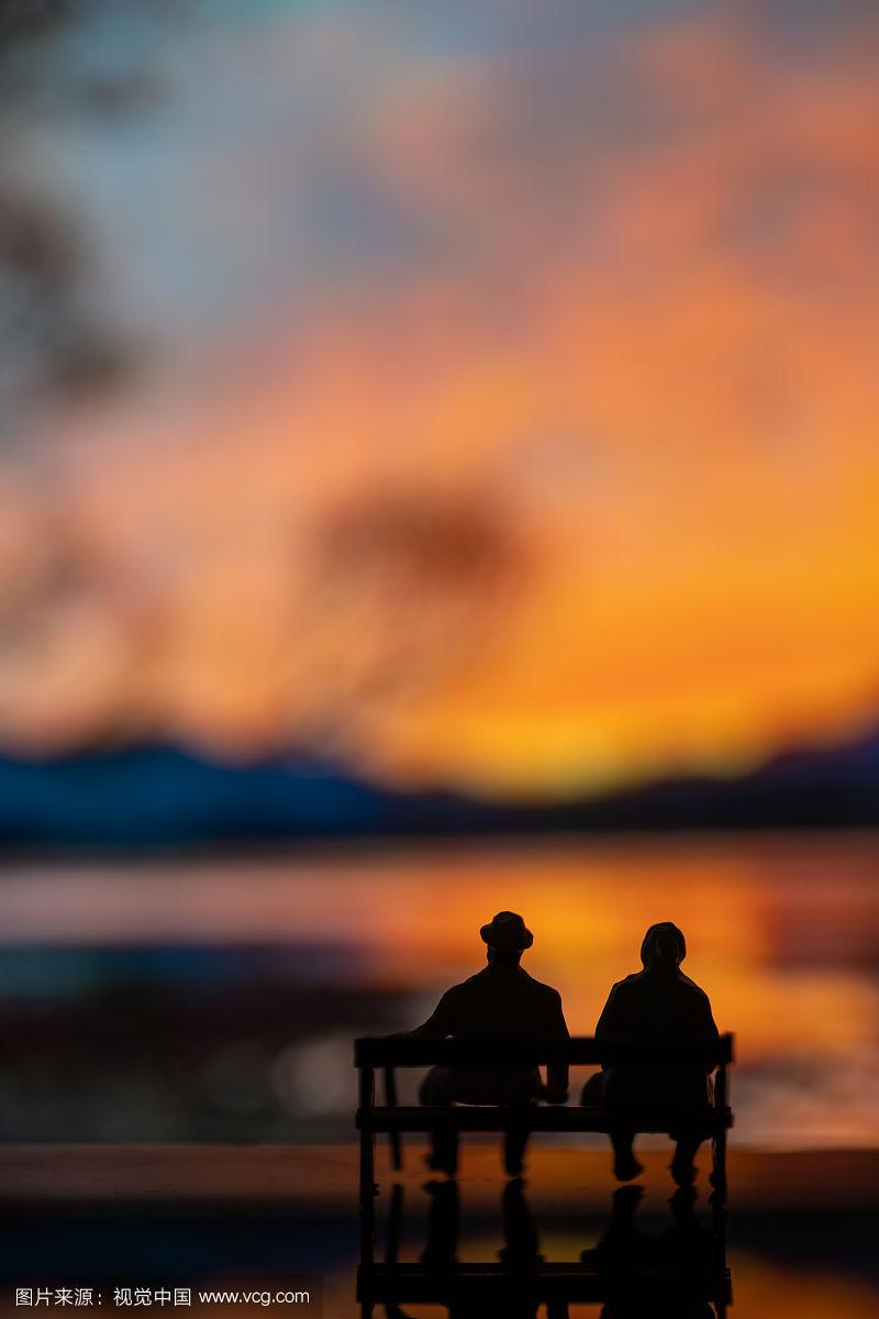 夕阳下坐在长椅上的老夫妻