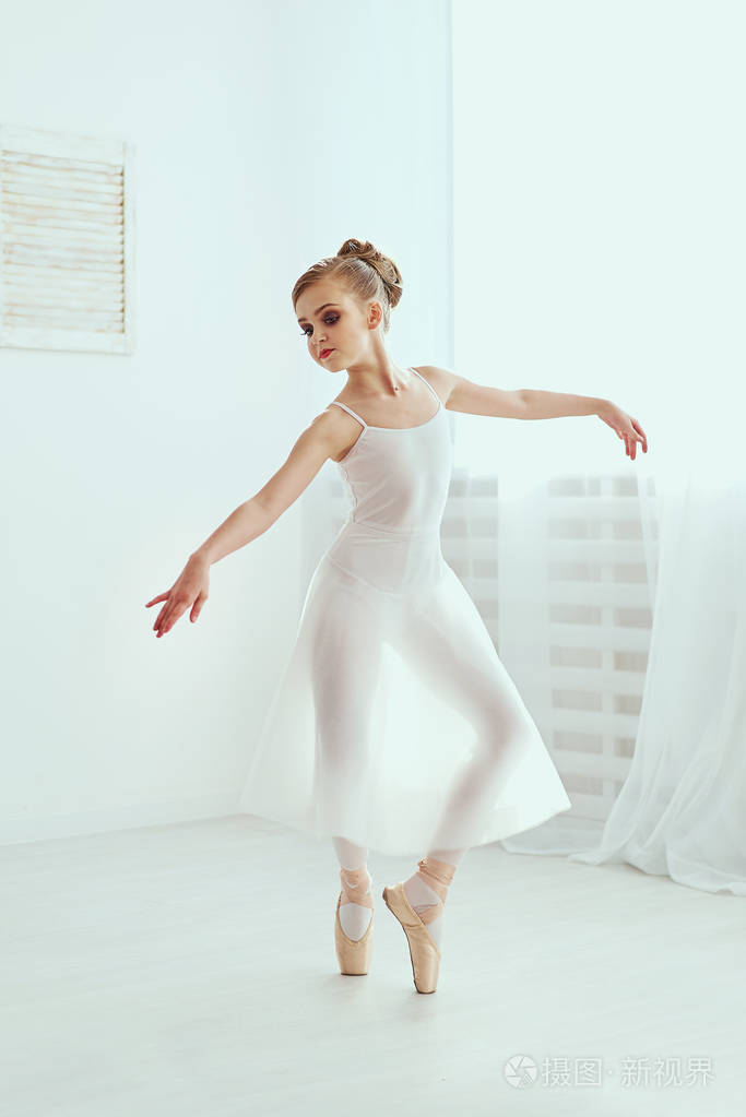 美丽的芭蕾舞演员在一个充满光线的白色工作室里摆姿势跳舞这张照片极