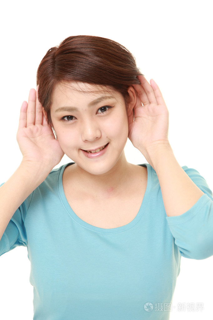 年轻女子用手仔细的倾听的耳朵后面