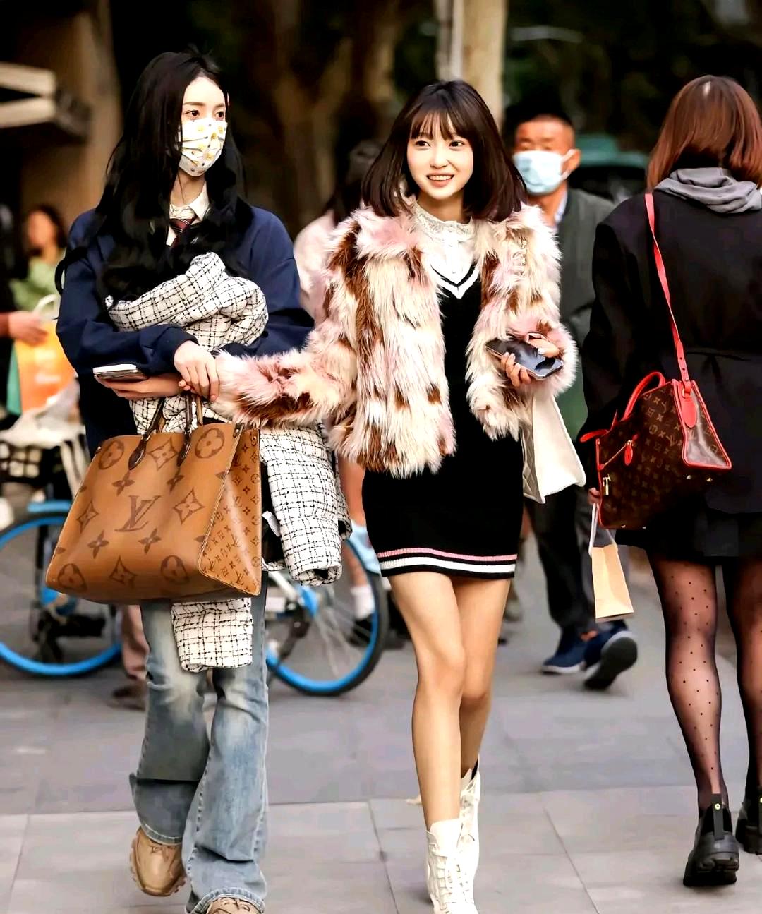 这条街上的人们穿着各式各样的衣服,有些人上身穿着羽绒服,下身却露出