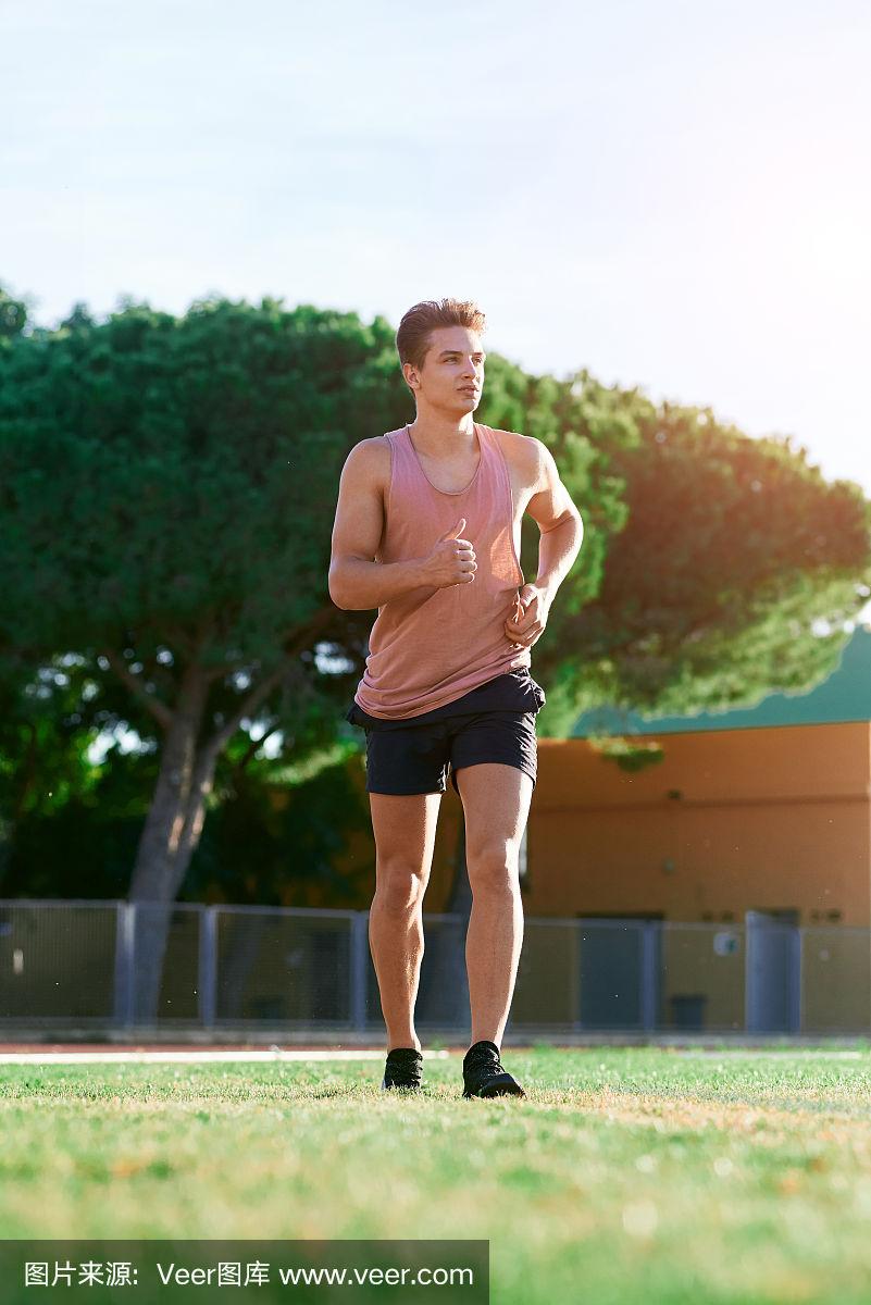 年轻的肌肉男在跑道上跑步