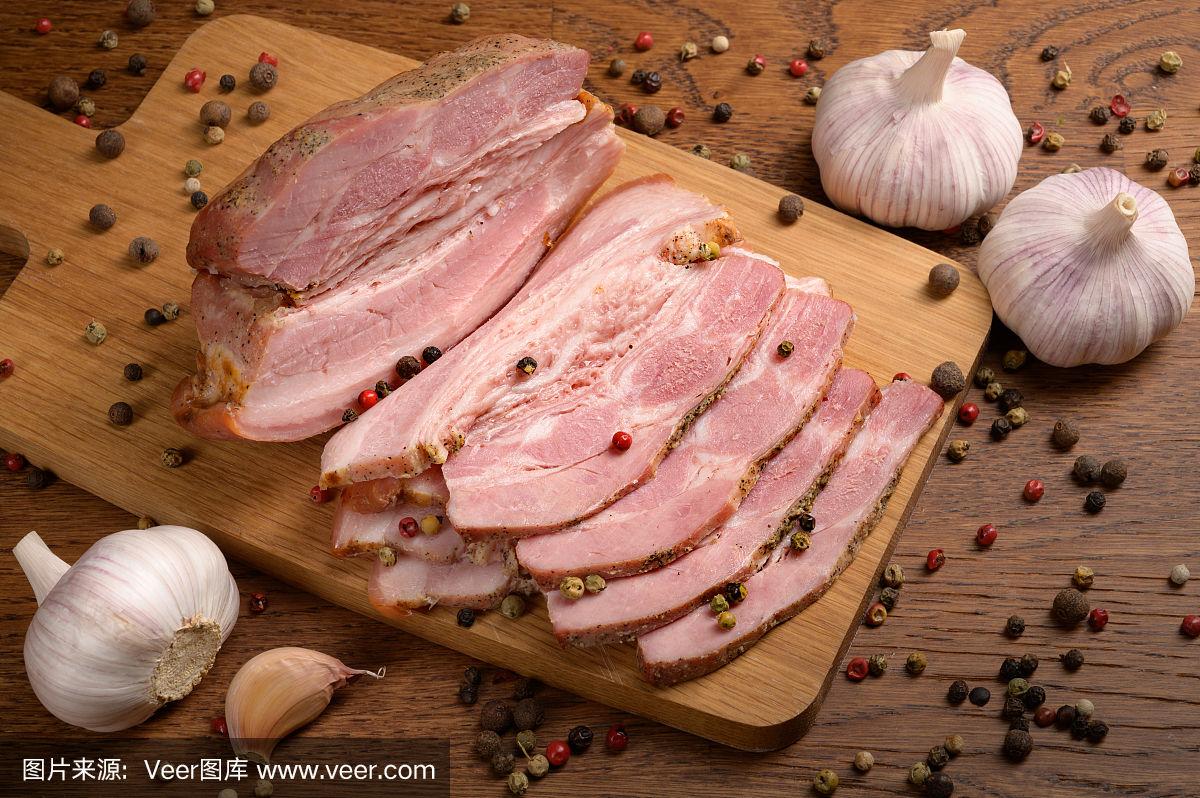 在木桌上切成片的熟肉加上香料和大蒜.