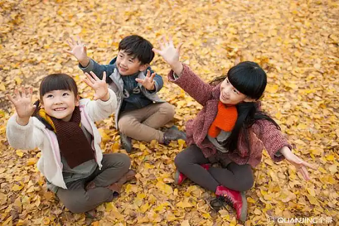 三个小孩伸手接落叶