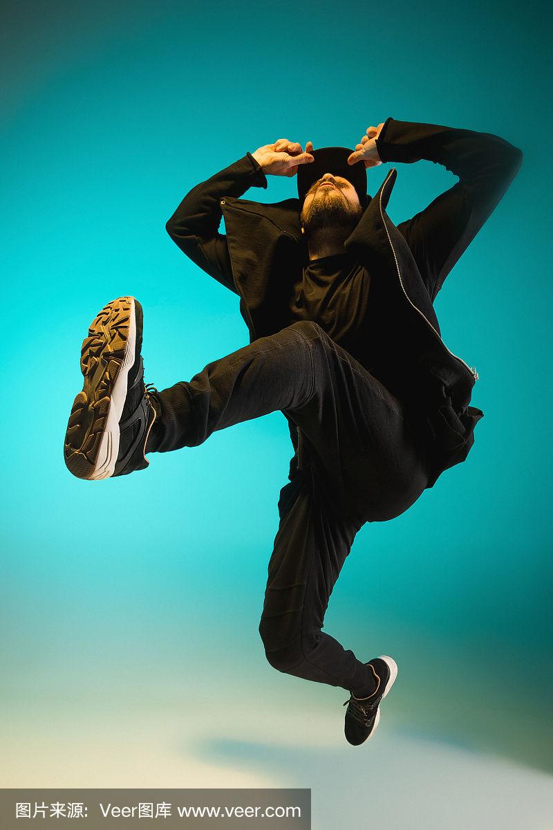 一个街舞男霹雳舞的剪影在多彩的背景上跳舞