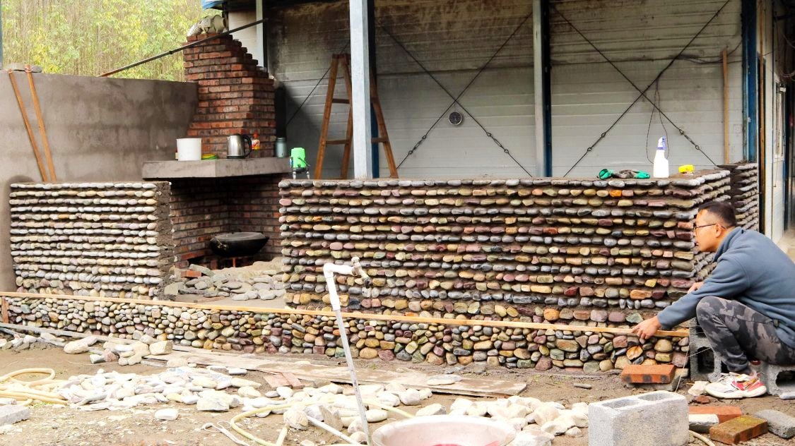 小伙自建景观墙耗费整整10天用掉7车鹅卵石这效果太震撼了