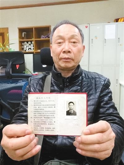 谭国华展示自己的退伍证11月16日,66岁的谭国华再次来到西安.