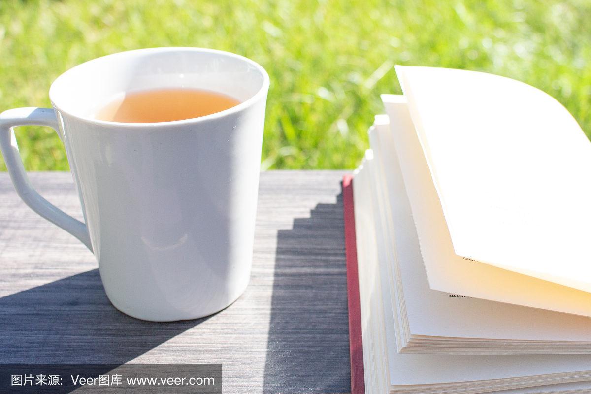 清晨,木桌上放着一杯茶和一本书